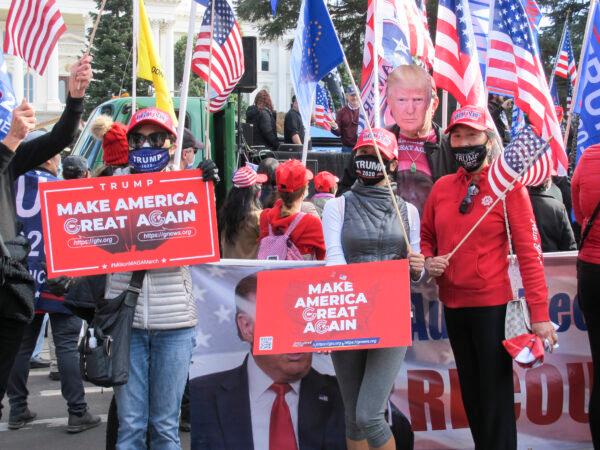 Rally attendees hold MAGA signs, and a person wears a printout of President Trump’s photo, in Sacramento, Calif., on Nov. 14, 2020. (Ilene Eng/The Epoch Times)