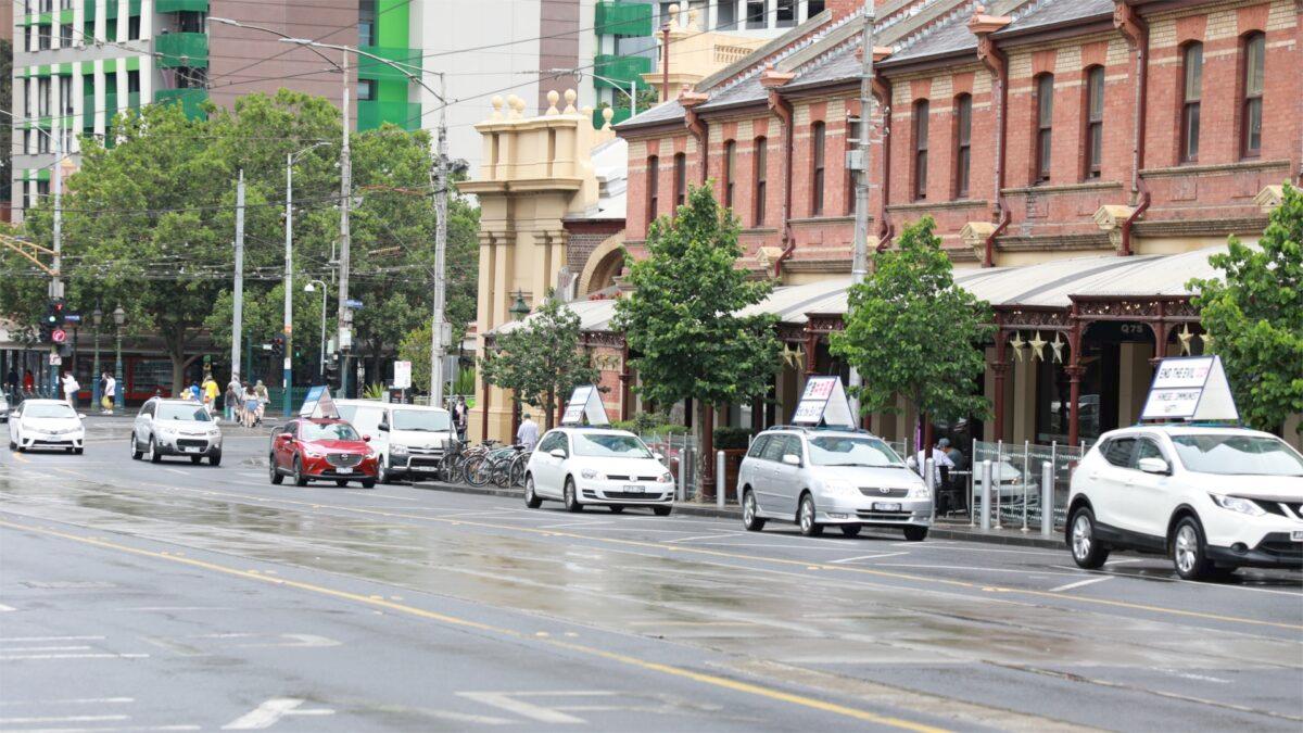 A line of cars with mounted signage driving through Melbourne CBD during an end CCP car rally on Nov. 22, 2020. (The Epoch Times)