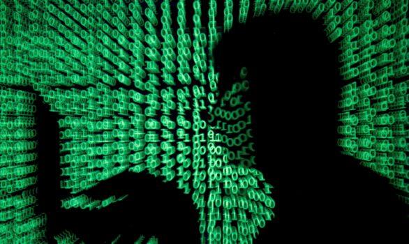 A man holds a laptop computer as cyber code is projected on him in this illustration picture taken on May 13, 2017. (Kacper Pempel/Reuters)