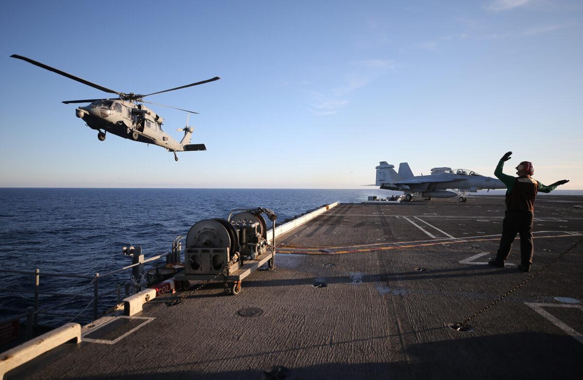 A U.S. Navy helicopter descends to land aboard the USS Nimitz aircraft carrier while off the coast of Baja California, Mexico, on Jan. 18, 2020. (Mario Tama/Getty Images)