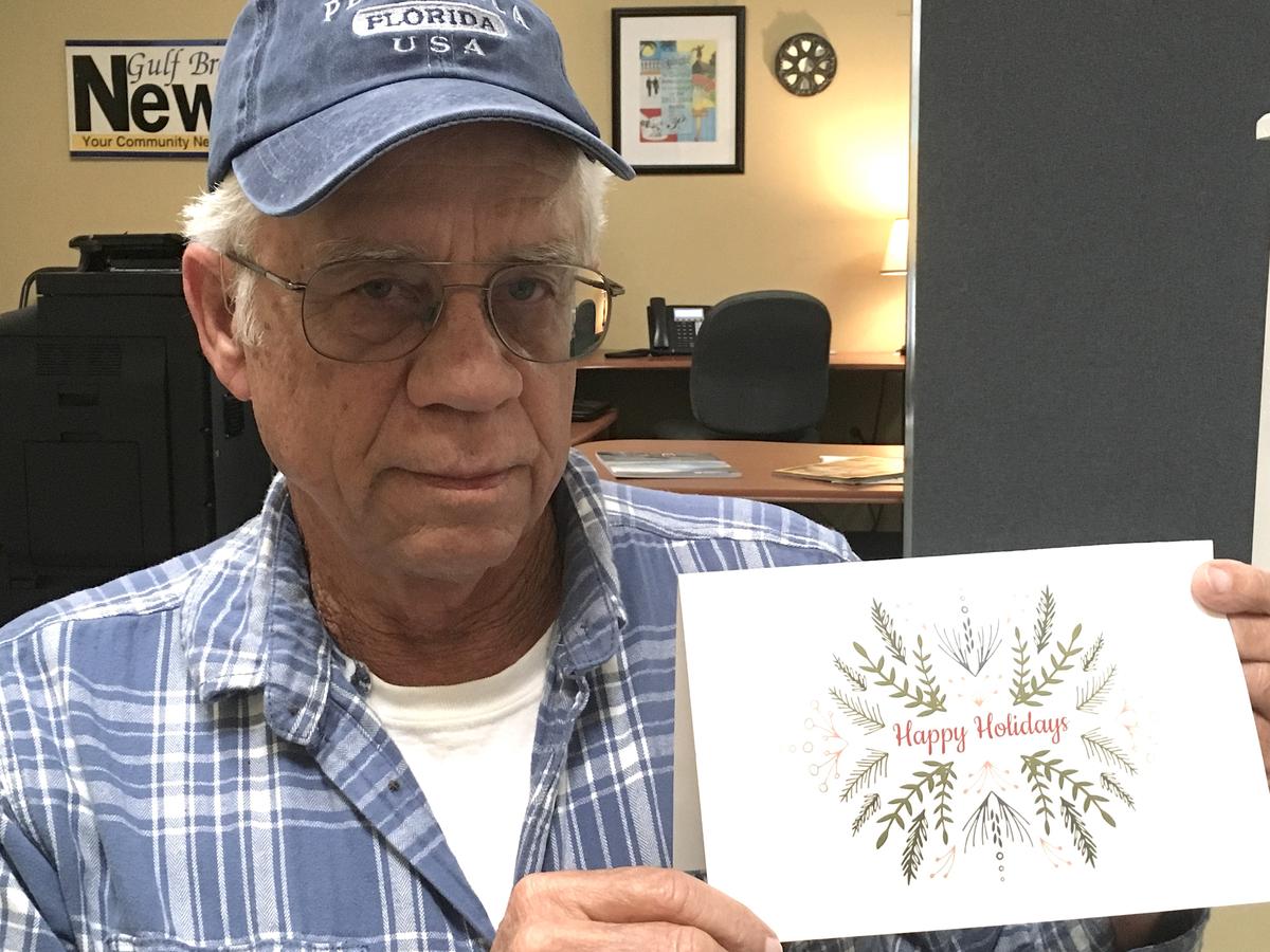 Mike Esmond holding the Christmas card from 2019 that the city sent out. (Courtesy of Gulf Breeze News)