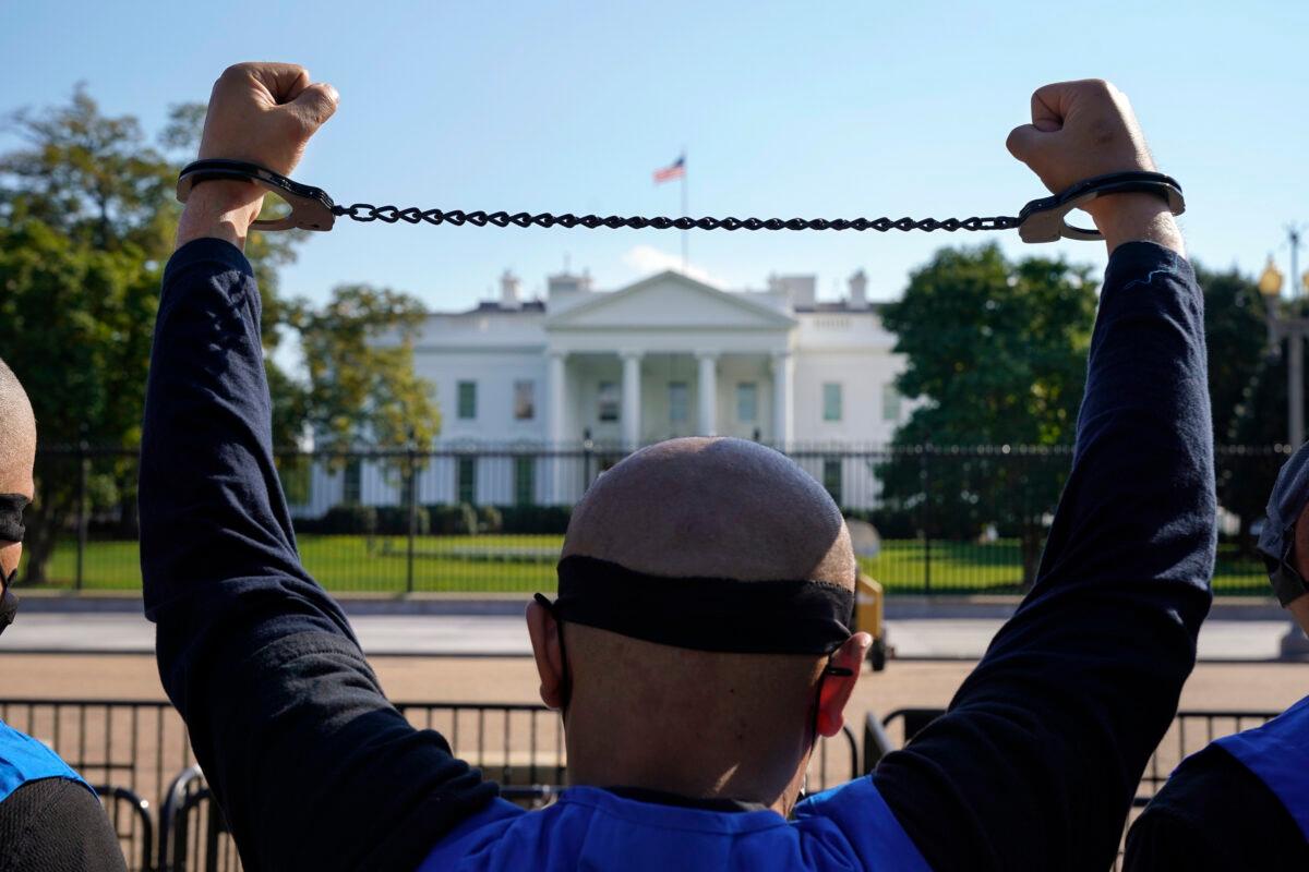 A member of the Uyghur American Association rallies in front of the White House in Washington on Oct. 1, 2020. People marched from Capitol Hill in Washington, in support of the Uyghur Forced Labor Prevention Act, which has passed the House and now will go on to the Senate. The bill prohibits some imports from Xinjiang and imposes sanctions for human rights violations. (Jacquelyn Martin/AP Photo)