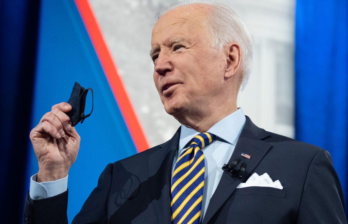 resident Joe Biden holds a face mask as he participates in a town hall at the Pabst Theater in Milwaukee, Wis., on Feb. 16, 2021. (Saul Loeb/AFP via Getty Images)