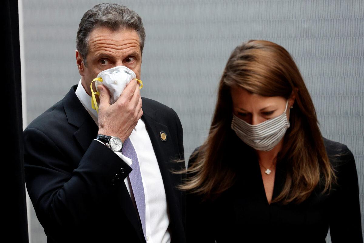 New York Gov. Andrew Cuomo holds a protective mask to his face as he and Secretary to the Governor Melissa DeRosa arrive for a briefing at New York Medical College in Valhalla, N.Y., on May 7, 2020. (Mike Segar/Reuters)