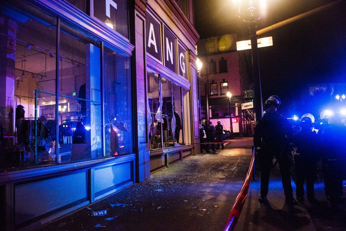 Workers board businesses as police confront protesters in Portland, Ore., on Nov. 4, 2020. (Kathryn Elsesser/AFP via Getty Images)