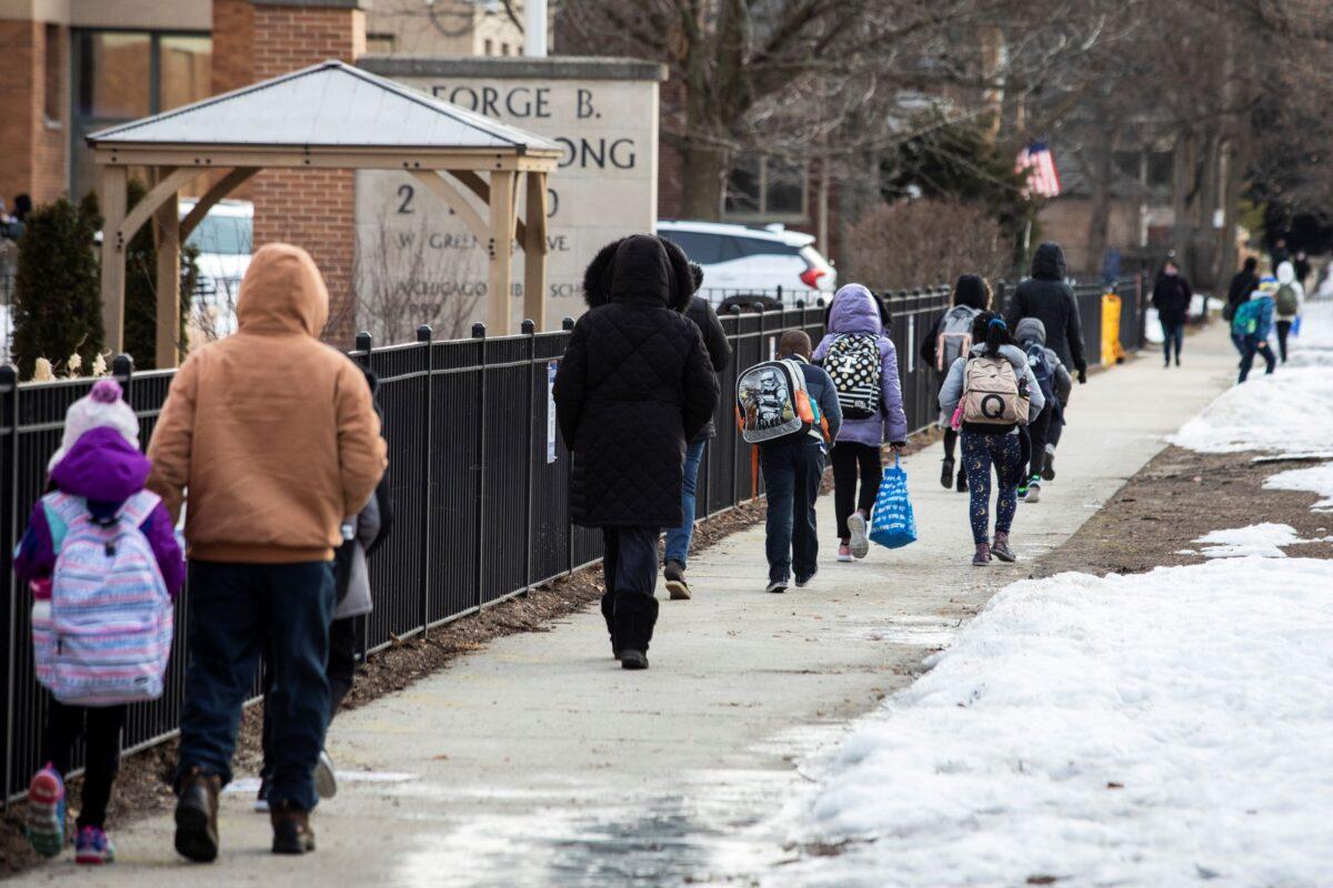 Parents and children line up outside George B. Armstrong International Studies Elementary School in Chicago, Ill., on March 1, 2021. (Ashlee Rezin Garcia/Chicago Sun-Times via AP)