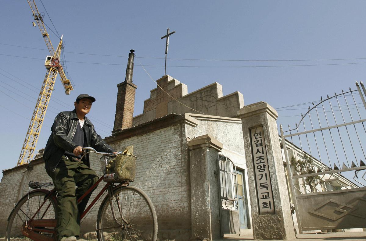A man cycles past an ethnic Korean Christian church in the town of Yanji in Yanbian Korean Autonomous Prefecture on the China/North Korea border, Oct. 13, 2006. (Peter Parks/AFP via Getty Images)