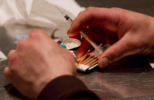 A man prepares heroin he bought on the street to be injected at the Insite safe injection clinic in Vancouver, B.C., on Wednesday, May 11, 2011. (THE CANADIAN PRESS/Darryl Dyck)