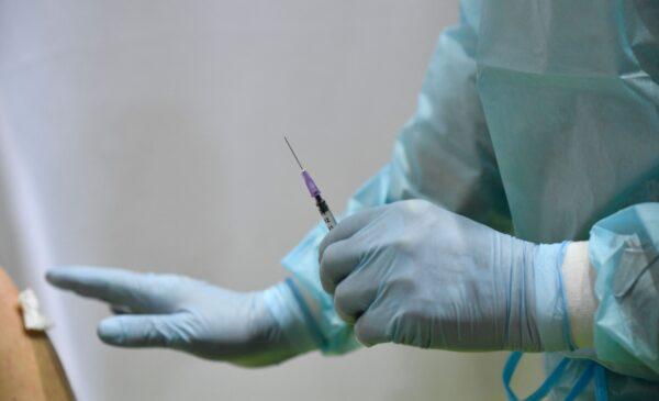 A health worker holds a syringe with the AstraZeneca vaccine against COVID-19 at a new vaccination center at the former Tempelhof airport in Berlin, Germany, on March 8, 2021. (Tobias Schwarz/various sources/AFP via Getty Images)