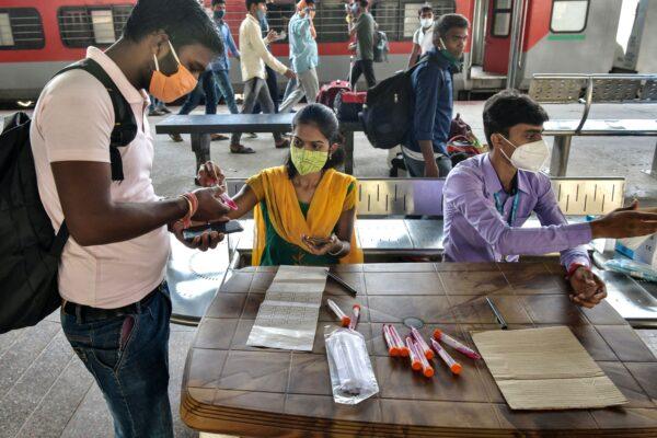 Health workers register passengers to collect samples for virus test at the Yesvantpur railway station in Bangalore, India, on April 5, 2021. (Manjunath Kiran/AFP via Getty Images)