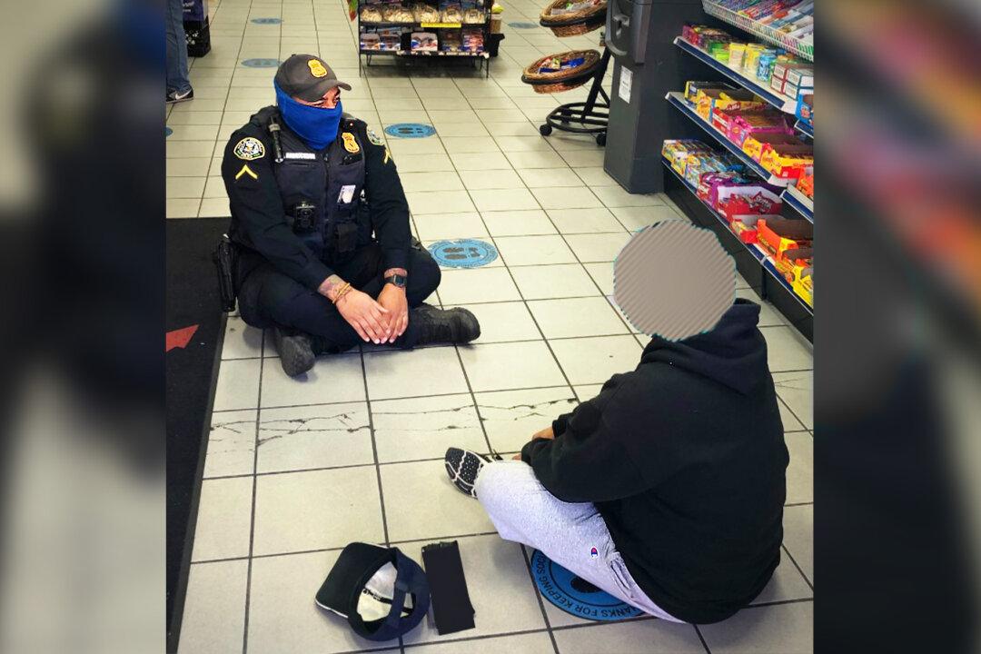 Photo Shows Kind Police Officer Sitting on Floor With Man in Mental Health Crisis in Gas Station