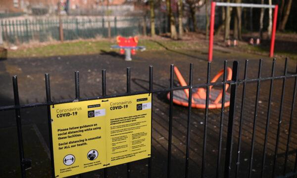 A COVID-19 information poster is pictured on the fence of an empty children's play park in Manchester, northern England, on February 15, 2021. (Oli Scarff/AFP via Getty Images)