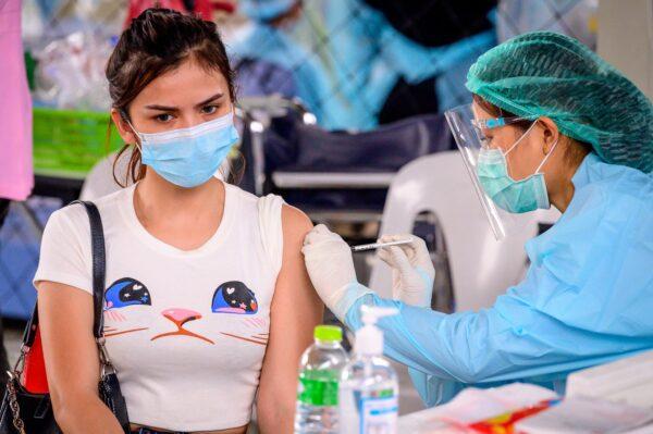 A health worker administers the CoronaVac vaccine, developed by China's Sinovac firm, to a woman from an at-risk group at Saeng Thip sports ground in Bangkok, Thailand on April 7, 2021. (MLADEN ANTONOV/AFP via Getty Images)