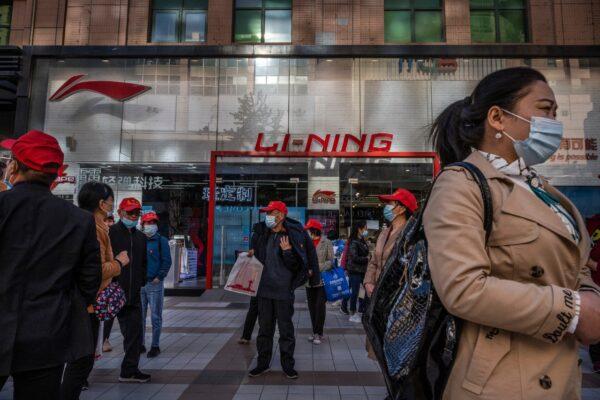 Tourists and shoppers walk by a Li-Ning store, a Chinese sportswear brand, at a shopping district in Beijing on April 16, 2021. (Kevin Frayer/Getty Images)