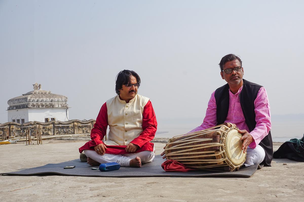 Classical vocalist Supriyo Maitro (L) and pakhawaj (barrel drum) player, Ravishankar Shukla (R) practice the Dhrupad style of Indian music at the Assi Ghat in the ancient city of Kashi on Feb. 19, 2021. (Venus Upadhayaya/Epoch Times)