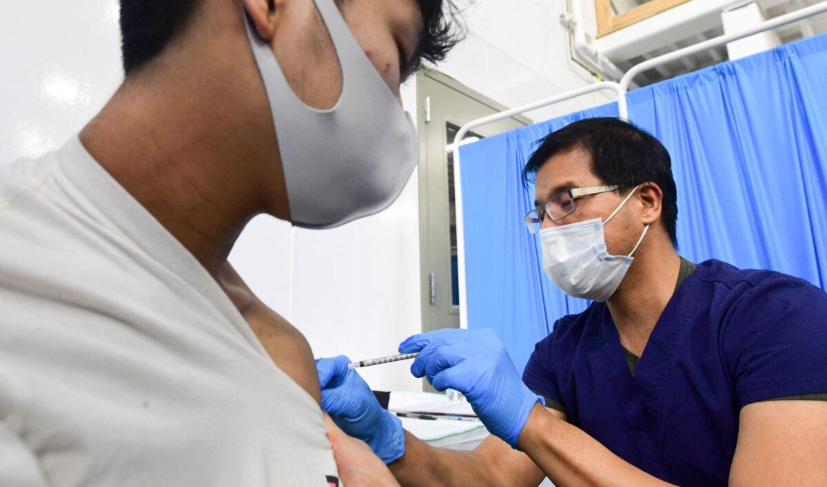 Registered Nurse Robert Orallo administers the Pfizer COVID-19 vaccine at the Blood Bank of Alaska in Anchorage on March 19, 2021. (Frederic J. Brown/AFP via Getty Images)