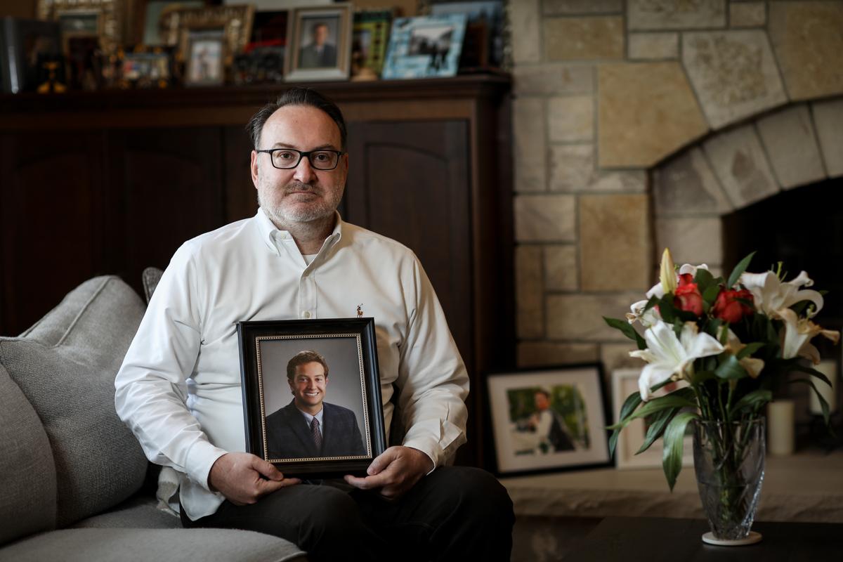 Chris Buckner, holds a photo of his son Dylan Buckner who committed suicide due to his depression being amplified by the lockdowns, at his home in Northbrook, Ill., on April 16, 2021. (Samira Bouaou/The Epoch Times)