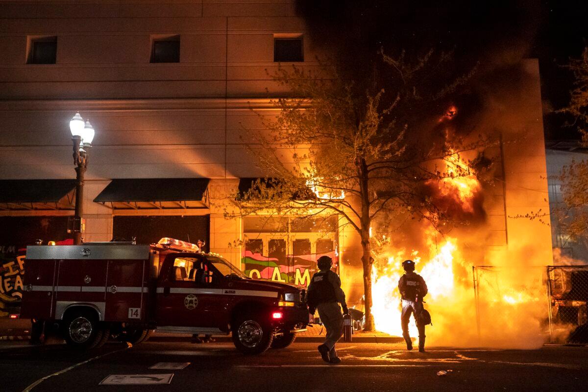 Portland police and fire crews respond to a fire set by rioters in Portland, Ore., on April 17, 2021. (Nathan Howard/Getty Images)