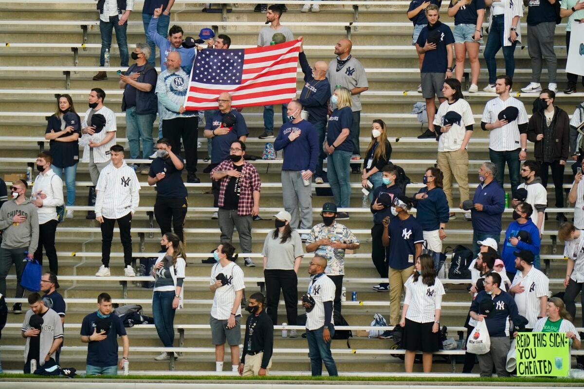 Fans stand during the playing of the national anthem before a baseball game between the New York Yankees and the Houston Astros in New York on May 4, 2021. (Frank Franklin II/AP Photo)