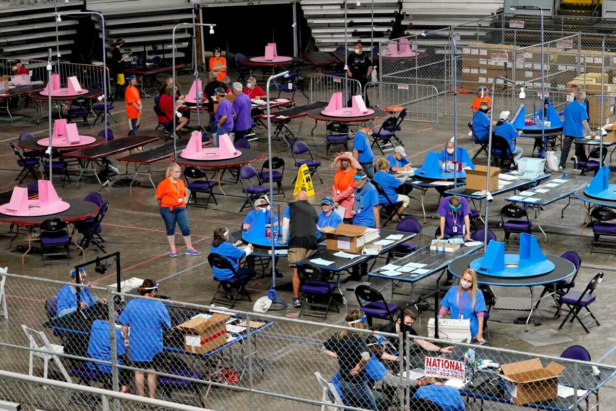 Contractors working for Florida-based company Cyber Ninjas, which was hired by the Arizona Senate, audit ballots at Veterans Memorial Coliseum in Phoenix on May 6, 2021. (Matt York/Pool/AP Photo)