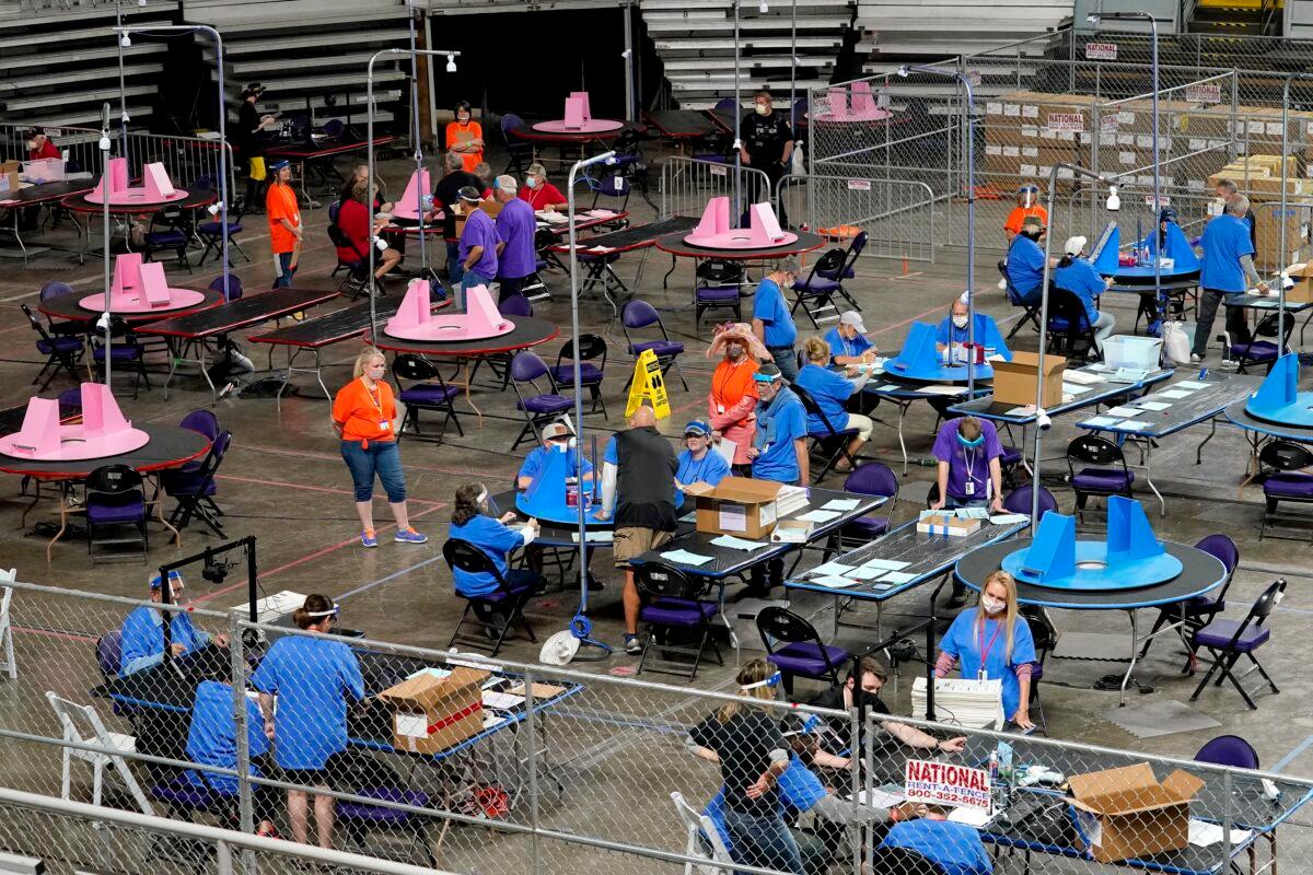 Maricopa County ballots cast in the 2020 general election are examined and recounted by contractors working for Florida-based company, Cyber Ninjas, at Veterans Memorial Coliseum in Phoenix, Ariz., on May 6, 2021. (Matt York/AP Photo/Pool)