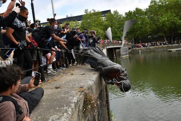 Protesters throwing the statue of Edward Colston into Bristol Harbour during a Black Lives Matter protest rally in Bristol, England, on June 7, 2020. (Ben Birchall/PA Media)