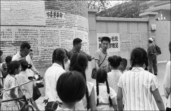 An angry Chinese man (middle R) is heckled and taken away by a plain-clothes militiaman (middle L) after trying to roll out and paste his hand-written placard or dazibao on the “dazibao wall” (background) in front of the Municipal Revolutionary Committee of Beijing in Beijing, China, in July 1974. Dazibaos were the only means for people to express their opinions. (Serge Romensky/AFP via Getty Images)