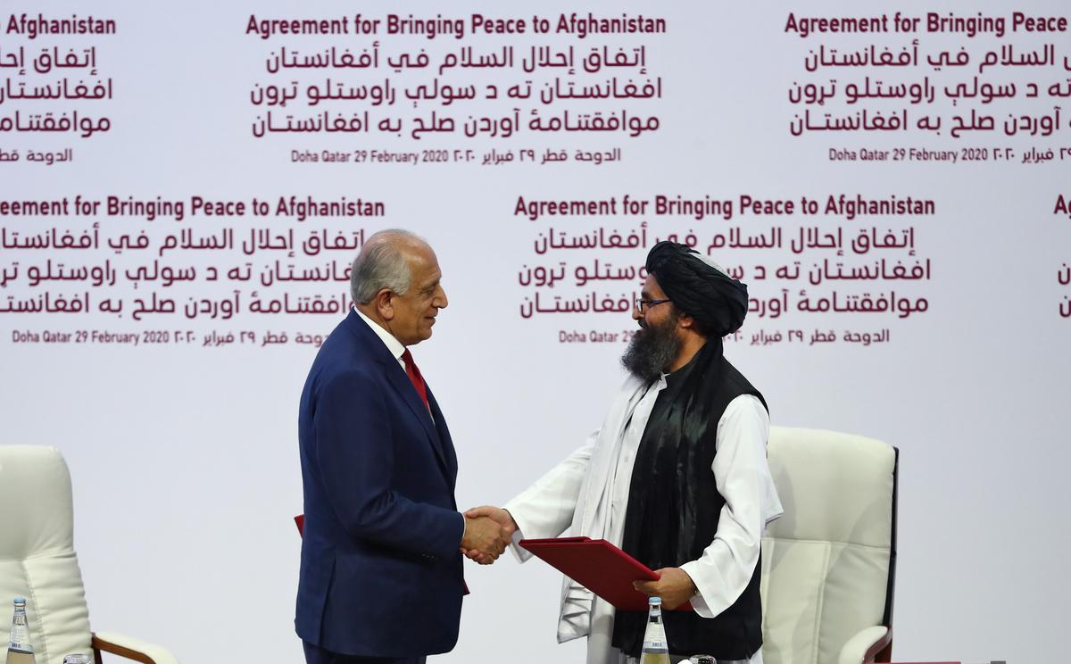 (L to R) U.S. Special Representative for Afghanistan Reconciliation Zalmay Khalilzad and Taliban co-founder Mullah Abdul Ghani Baradar shake hands after signing a peace agreement during a ceremony in Doha, Qatar, on Feb. 29, 2020. (Karim Jaafar/AFP via Getty Images)