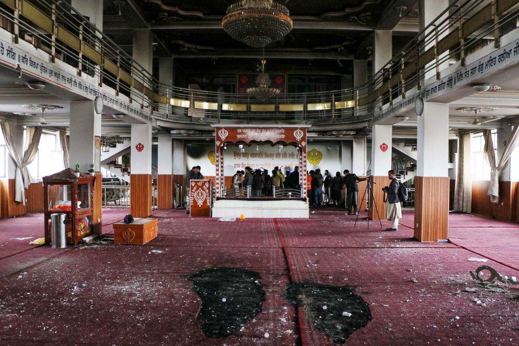Security personnel inspect a damaged Sikh-Hindu Temple alongside media representatives following a gun attack in Kabul on March 25, 2020. (STR/AFP via Getty Images)