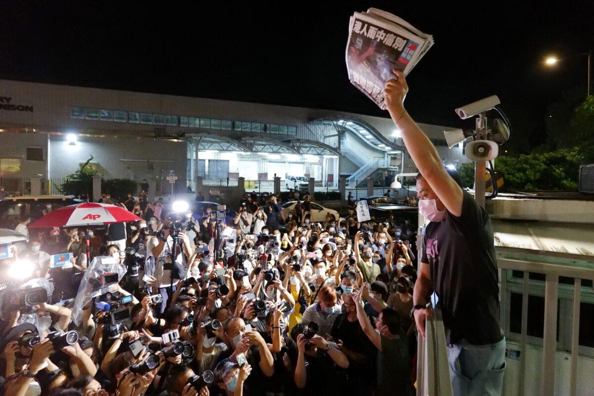 An Apple Daily journalist holds freshly-printed copies of the newspaper's last edition to be distributed to supporters gathered outside their office in Hong Kong early on June 24, 2021. (Daniel Suen/AFP via Getty Images)