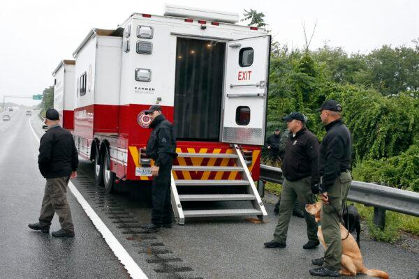 Police work on in the area of an hourslong standoff with a group of armed men that partially shut down Interstate 95, in Wakefield, Mass., on July 3, 2021. (Michael Dwyer/AP Photo)