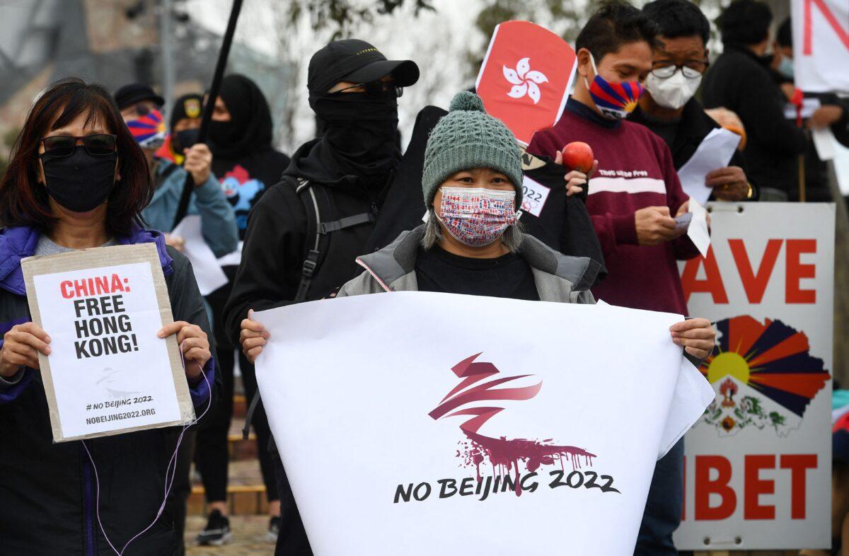 Activists including members of the local Hong Kong, Tibetan and Uyghur communities hold up banners and placards in Melbourne, Australia, on June 23, 2021, calling on the Australian government to boycott the 2022 Beijing Winter Olympics over China's human rights record. (William West/AFP via Getty Images)