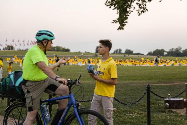 A Falun Gong practitioner talks to a passerby at an event marking the 22nd anniversary of the start of the Chinese regime’s persecution of Falun Gong, in Washington on July 16, 2021. (Samira Bouaou/The Epoch Times)
