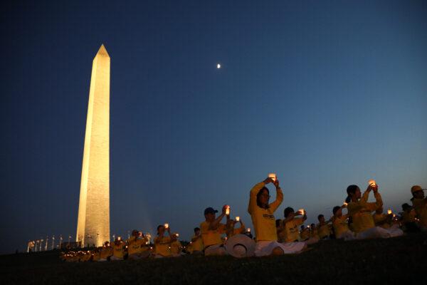 Falun Gong practitioners take part in a candlelight vigil remembering victims of the 22-year-long persecution in China at the Washington Monument on July 16, 2021. (Samira Bouaou/The Epoch Times).