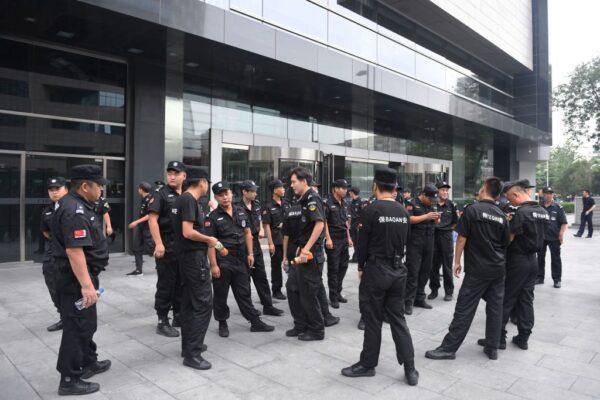 Security personnel stand in front of China's Banking Regulatory Commission in Beijing on Aug. 6, 2018, after Chinese police aggressively quashed a planned protest against losses sustained by peer-to-peer (P2P) lending platforms. (Greg Baker/AFP via Getty Images)