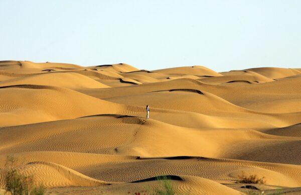 A visitor stands in Taklamakan Desert near Yutian county, Xinjiang Region, China on Oct. 12, 2006. (Guang Niu/Getty Images)
