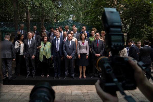 Jim Nickel (front C), the deputy chief of mission for the Canadian Embassy in China, and diplomatic representatives from more than two dozen other countries pose for a group photo at an event held in connection with the announcement of the sentence for Canadian citizen Michael Spavor at the Canadian Embassy in Beijing, on Aug. 11, 2021. (Mark Schiefelbein/AP Photo)