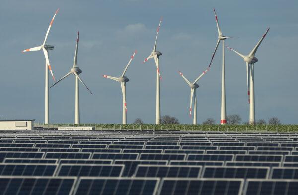 Wind turbines stand behind a solar power park near Werder, Germany on Oct. 30, 2013. (Sean Gallup/Getty Images)