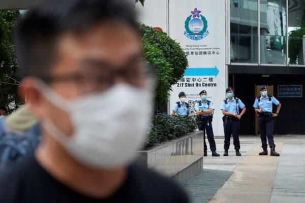 Police offices stand guard as pro-democracy activist Raphael Wong arrives at a local court in Hong Kong. A trial opens for seven prominent Hong Kong pro-democracy activists including Wong. Aug. 19, 2021. (Vincent Yu/AP Photo)