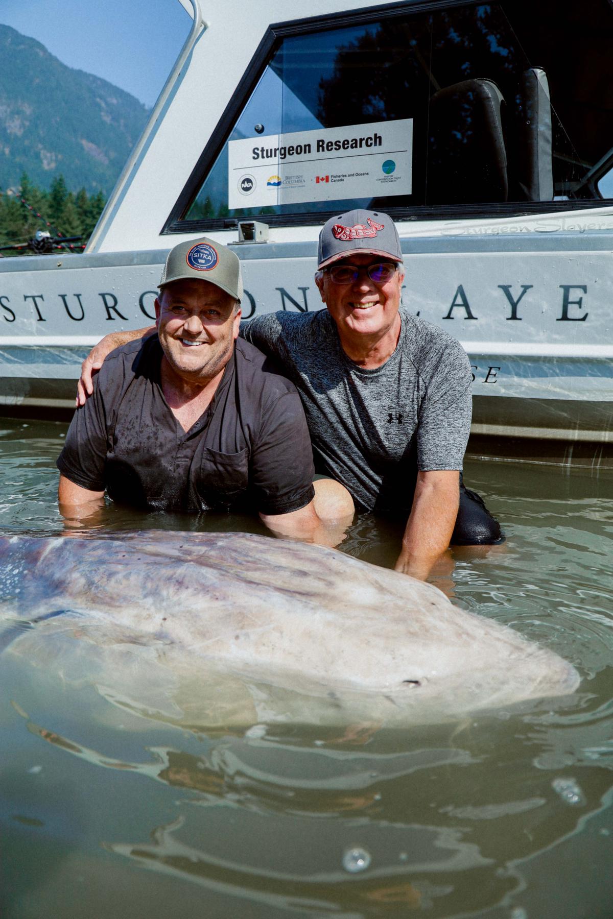 Longtime Sturgeon Slayers guests Bryant Bowtell (L) and brother Barry pose with the sturgeon. (Courtesy of <a href="http://www.sturgeonslayers.com/">Sturgeon Slayers</a>)