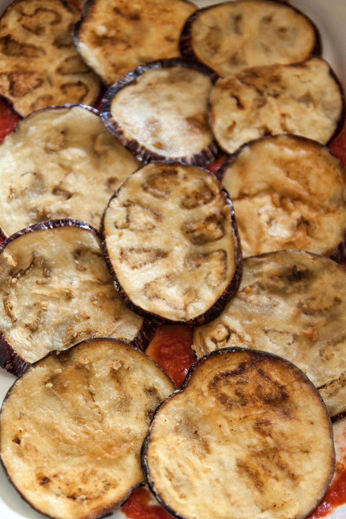 Start with a layer of tomato sauce and fried eggplants. (Giulia Scarpaleggia)