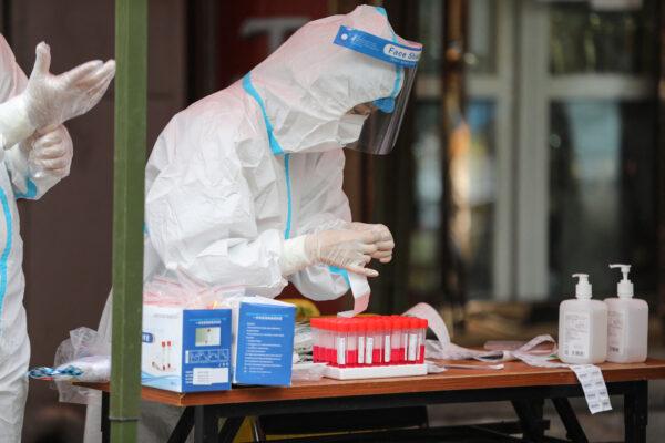 A medical worker collects a sample to be tested for the CCP virus in Harbin, in China's northeastern Heilongjiang Province on Sept. 22, 2021. (STR/AFP via Getty Images)