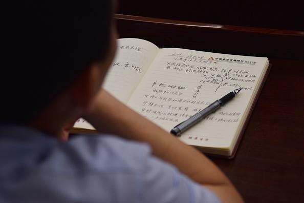 An adult student taking notes on 'Xi Jinping Thought' in a class at the Party School of the Chinese Communist Party's Central Committee during a government-organized tour for foreign journalists in Beijing. The normally highly secretive Central School of the Communist Party opened its doors to foreign media on June 26, 2019, for a tightly controlled visit in which little was left to chance. (Leo Ramirez/AFP via Getty Images)