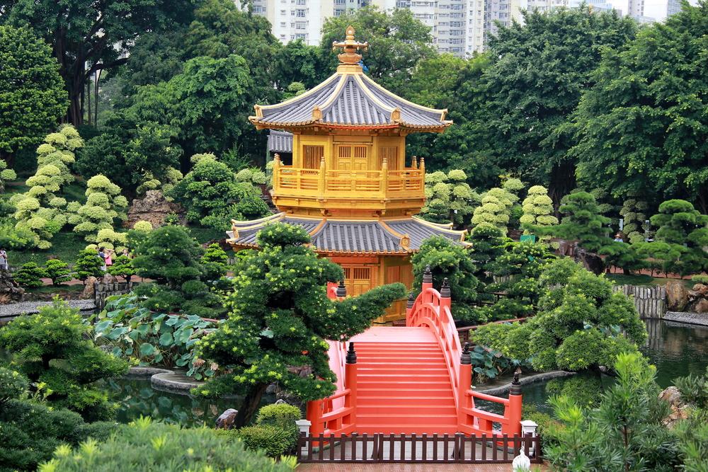 One of two vermilion arched bridges, amid the vibrant green landscape, draws the eye to the Pavilion of Absolute Perfection. (TINNAKON BOONJAD/Shutterstock)