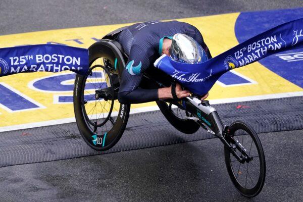 Marcel Hug of Switzerland breaks the finish line with his helmet to win the men's wheelchair division at the Boston Marathon in Boston on Oct. 11, 2021. (Charles Krupa/AP Photo)