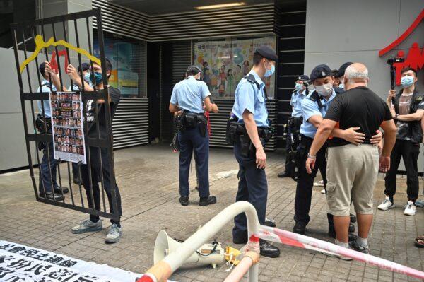 A protester (R) is searched by police as Hong Kong began selecting a powerful committee under a new "patriots only" system imposed by Beijing, in Hong Kong, on September 19, 2021. (Peter Parks/AFP via Getty Images)
