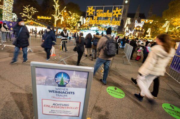 A sign warns visitors about controls of their status—vaccinated or healed from COVID-19—at the entrance to the 'Christkindlmarkt' Vienna's classic Christmas Market, on the square in front of the City Hall in Vienna, Austria, on Nov. 12, 2021. (GEORG HOCHMUTH/APA/AFP via Getty Images)