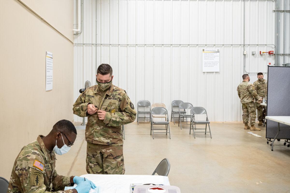 Preventative Medicine Services NCOIC Sgt. First Class Demetrius Roberson prepares to administer a COVID-19 vaccine to a soldier in Fort Knox, Kentucky, on Sept. 9, 2021. (Jon Cherry/Getty Images)