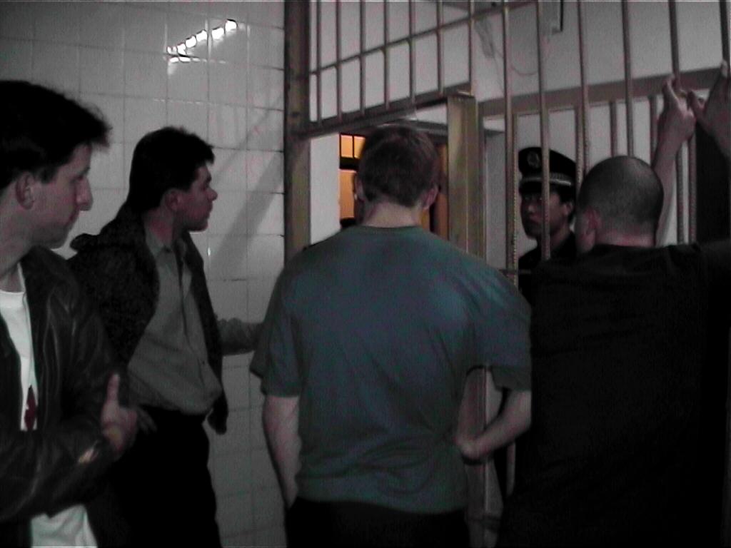 European Falun Gong practitioners talk to a policeman from inside the underground jail in a police station near Tiananmen Square in Beijing, on Nov. 20, 2001. (Courtesy of Adam Leining)