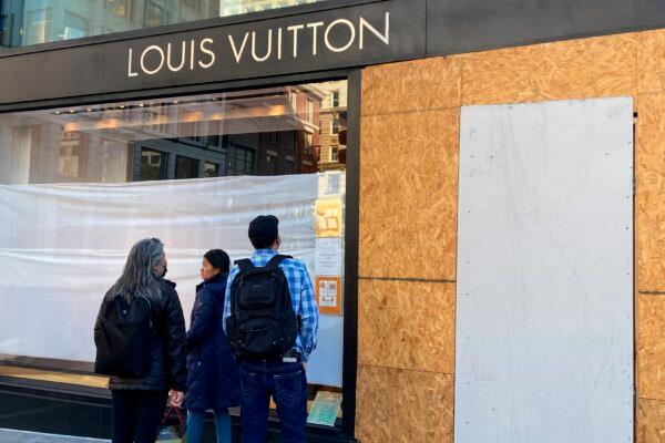 Union Square visitors look at damage to a Louis Vuitton store in San Francisco on Nov. 21, 2021. (Danielle Echeverria/San Francisco Chronicle via AP)